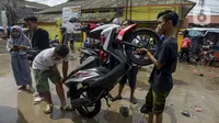 Pengendara motor membuang air yang masuk ke dalam knalpot saat melintasi banjir di Jalan Husein Nastranegara Perapatan Rawa Bokor, Tangerang, Sabtu (1/2/2020). Hujan deras yang mengguyur sejak Jumat (31/1) malam menyebabkan sejumlah kawasan di Tangerang terandam air. (merdeka.com/Imam Buhori)