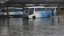 Bus melintasi banjir akibat air laut pasang atau rob yang menggenangi Terminal Terboyo di Semarang, Minggu (15/5/2016). Banjir rob tersebut mengakibatkan penumpang memilih turun di luar terminal, sehingga aktivitas di dalam terminal lumpuh. (Foto: Gholib)