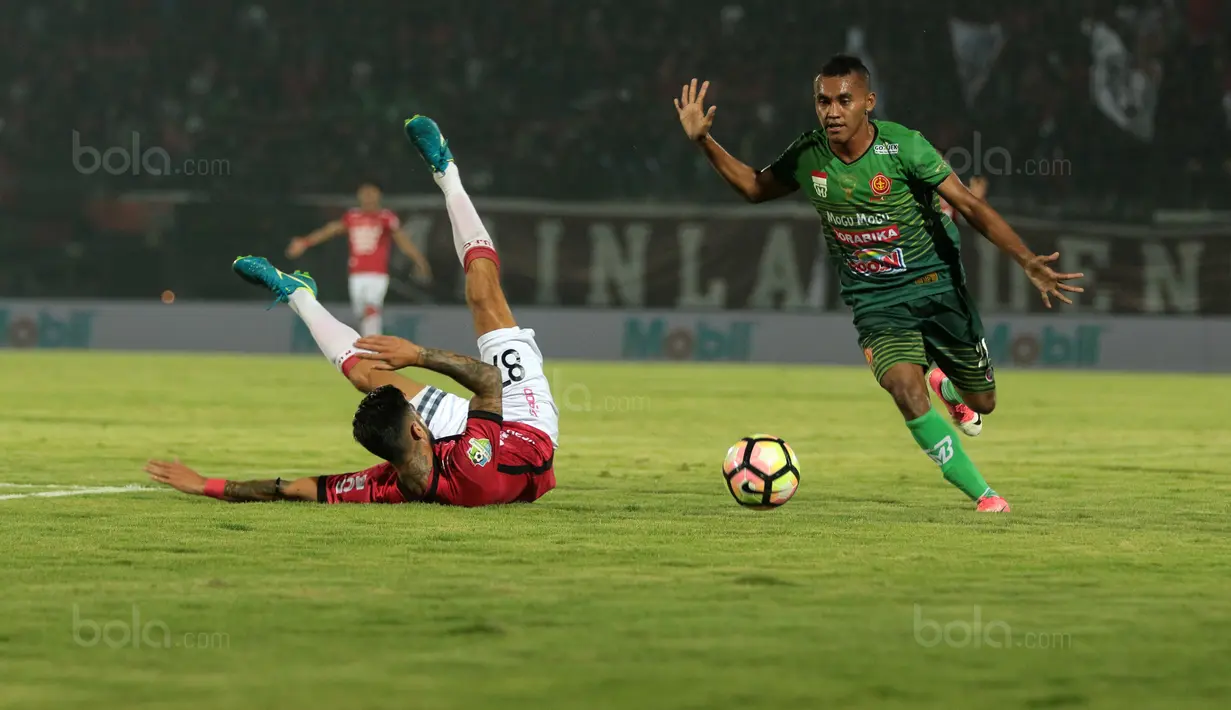 Pemain Bali United, Stefano Lilipaly terjatuh saat berebut bola dengan pemain PS TNI, Muhammad Kasim pada lanjutan Liga 1 2017 di Stadion Kapten I Wayan Dipta, Gianyar, Bali (20/102017). Bali United menang 2-1. (Bola.com/NIcklas Hanoatubun)