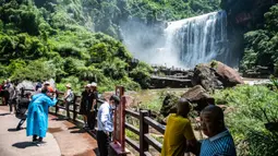 Sejumlah wisatawan menikmati pemandangan Air Terjun Chishui di Chishui, Provinsi Guizhou, China, Senin (15/6/2020). Kota Chishui sering disebut Kota Seribu Air Terjun, keindahannya menarik wisatawan dari seluruh negeri. (Xinhua/Tao Liang)