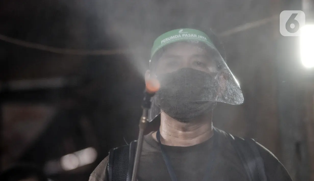 Petugas menyemprotkan cairan disinfektan saat sterilisasi rutin Pasar Sumur Batu, Kemayoran, Jakarta, Rabu (8/7/2020). Pengelola Pasar Sumur Batu rutin melakukan penyemprotan disinfektan setiap Senin, Rabu, dan Jumat guna mencegah penyebaran virus corona COVID-19. (merdeka.com/Iqbal S. Nugroho)