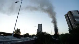 Pemandangan dari jauh gedung apartemen bertingkat 27 lantai yang terbakar di London (14/6). Pernyataan dari kepala pemadam kebakaran, api telah menjalar dari lantai dua hingga paling atas. (AP Photo/Matt Dunham)