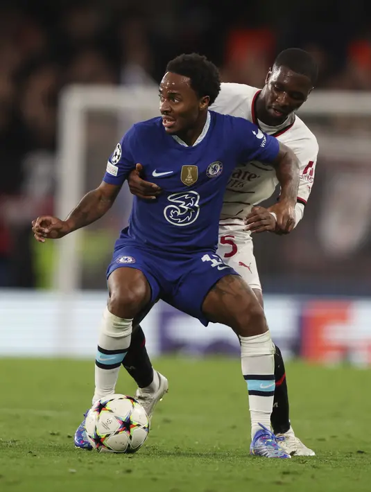 Penyerang Chelsea Raheem Sterling ditekel oleh bek AC Milan Fode Ballo-Toure pada matchday ketiga Grup E Liga Champions 2022/23 di Stamford Bridge, Kamis (6/10/2022) dini hari WIB. Tiga gol The Blues lahir dari Wesley Fofana dan Pierre-Emerick Aubameyang. Kemudian gol penutup lahir dari kaki Reece James. (AP Photo/Ian Walton)