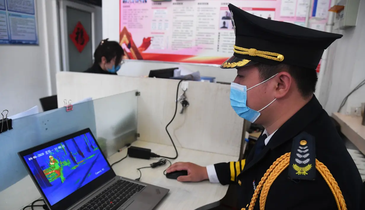 Petugas memeriksa foto yang dikirim oleh mobil pengiriman tanpa awak di Institut Teknologi Beijing, Beijing, China, Senin (6/4/2020). Institut Teknologi Beijing menggunakan mobil pengiriman tanpa awak berteknologi 5G yang dapat mengukur suhu tubuh orang-orang yang memasuki kampus. (Xinhua/Ren Chao)