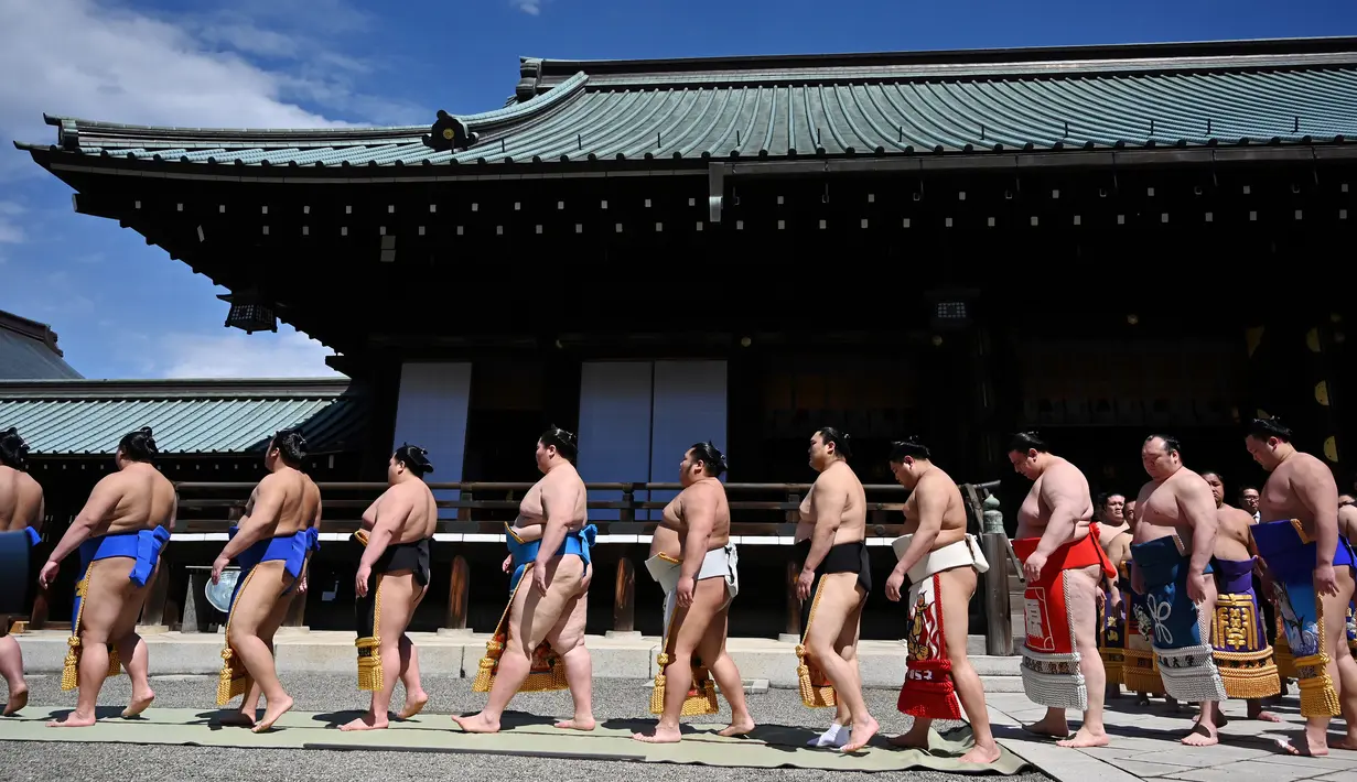 Para pegulat sumo jalan berbaris saat akan mengikuti turnamen Honozumo di Kuil Yasukuni, Tokyo, Jepang, 15 April 2019. (TRIBALLEAU CHARLY/AFP)