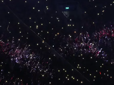 Ribuan penonton menyalakan flash ligt di ponselnya masing-masing saat malam penutupan Asian Games 2018 di Stadion GBK, Jakarta, Minggu (9/2). Hal ini menjadi unik dan menambah syahdu malam penutupan Asian Games 2018. (Liputan6.com/Helmi Fithriansyah)