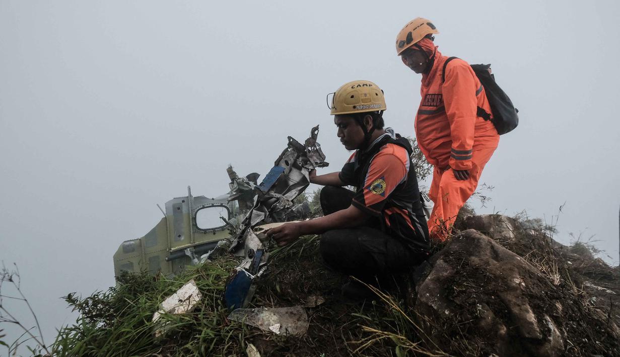 Personel tim pencarian dan penyelamatan melihat puing-puing pesawat turboprop Indonesia Air Transport berjenis ATR 42-500 di Gunung Bulusaraung, Sulawesi Selatan pada Minggu 18 Januari 2026. Tim gabungan terus mengoptimalkan operasi pencarian dan penyelamatan korban kecelakaan pesawat turboprop Indonesia Air Transport berjenis ATR 42-500 di Gunung Bulusaraung, Sulawesi Selatan. (Muchtamir Zaide/AFP)