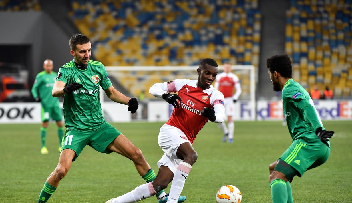 Aksi penyerang muda Arsenal, Eddie Nketiah melewati dua pemain Vorskla pada laga lanjutan Grup E Liga Europa yang berlangsung stadion NSK Olimpiyskiy, Kyiv, Jumat (30/11). Arsenal menang atas Vorskla 3-0. (AFP/Sergei Supinsky)