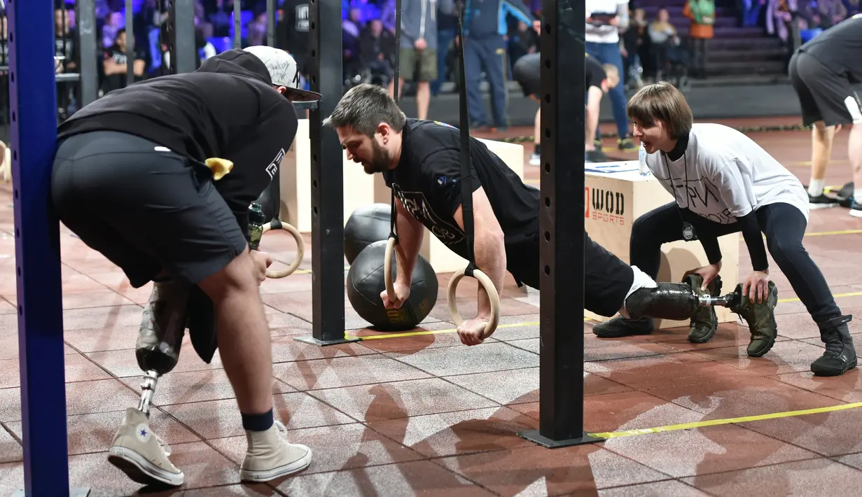 Para peserta mengikuti kompetisi final CrossFit "Game of Heroes" di Kiev, Ukraina (24/12). CrossFit sendiri adalah pola latihan yang mengabungkan olahraga kardiovaskuler dengan angkat beban ke dalam format serupa latihan sirkuit. (AFP/Sergei Supinsky)