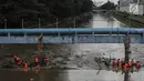 Pasukan oranye membersihkan sampah yang tersangkut di aliran sungai Ciliwung di kawasan Sudirman, Jakarta, Jumat (9/2). Meningkatnya debit air di Bendungan Katulampa, aliran air yang masuk ke Sungai Ciliwung membawa sampah. (Liputan6.com/Faizal Fanani)