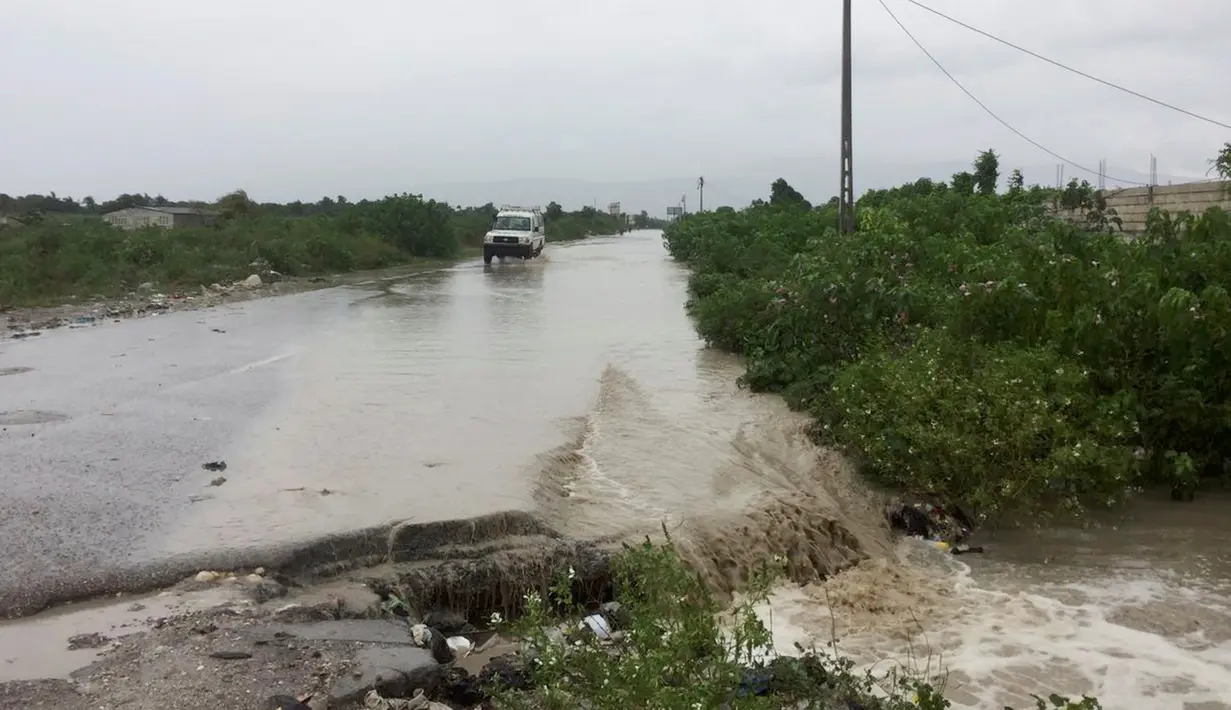 Sebuah mobil melintasi jalan  yang tergenang banjir saat Badai Matthew lewat n Port-au-Prince, Haiti, (4/10). (REUTERS/Carlos Garcia Rawlins)