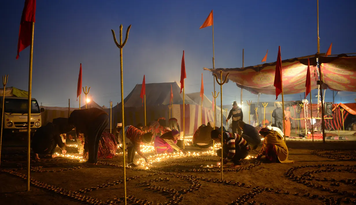 Umat Hindu India menyalakan lampu minyak untuk perayaan tradisional Magh Mela di Sangam, India (2/1). Dalam acara tersebut mereka berdoa dan melakukan ritual penyucian diri di Sangam. (AFP Photo/Sanjay Kanojia)