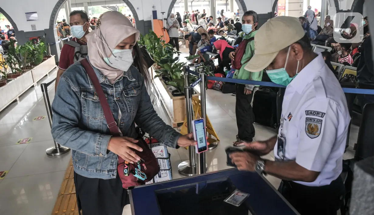 Petugas memeriksa kelengkapan syarat penumpang kereta api jarak jauh sebelum memasuki peron di Stasiun Pasar Senen, Jakarta Pusat, Minggu (17/7/2022). Selain itu PT KAI juga menyediakan layanan vaksinasi dosis ketiga atau booster secara gratis di stasiun keberangkatan. (merdeka.com/Iqbal S Nugroho)