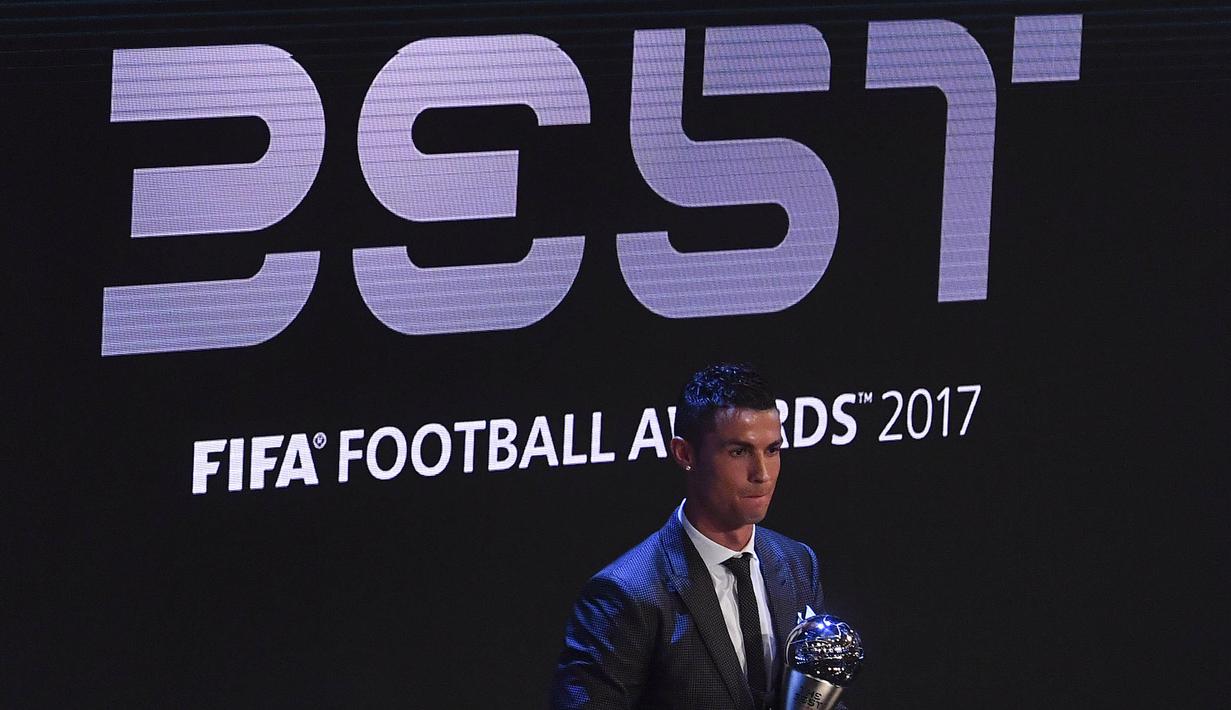 Bintang Real Madrid, Cristiano Ronaldo, pose bersama trofi pemain terbaik FIFA 2017 di London, Senin (23/10/2017) Ronaldo berhasil mengalahkan Lionel Messi dan Neymar yang juga menjadi nominasi. (AFP/Ben Stansall)