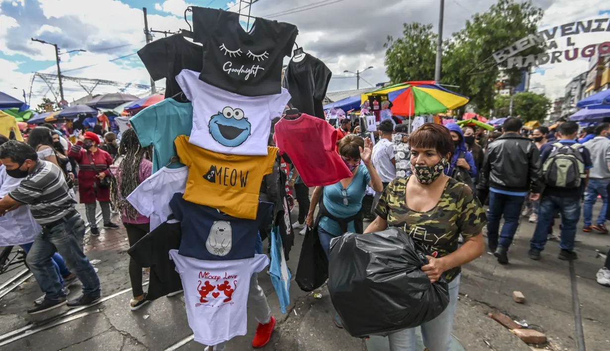 Orang-orang berbelanja hadiah Natal di jalan komersial di San Victorino, Bogota, Kolombia, Senin (21/12/2020). Kolombia, pada pekan lalu, kasus virus corona COVID-19 yang dikonfirmasi setiap harinya telah mencapai level tertinggi sejak pertengahan Agustus. (Juan BARRETO/AFP)