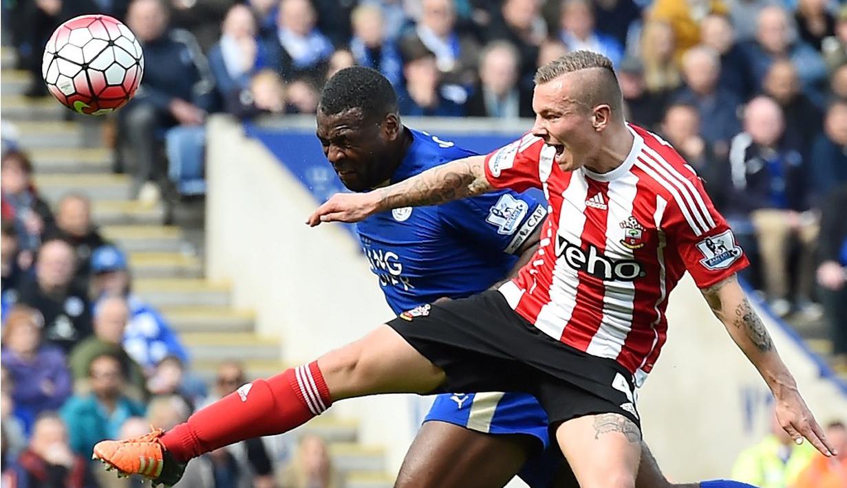 Pemain Leicester, Wes Morgan (kiri), berebut bola dengan pemain Southampton, Jordy Clasie, dalam laga Liga Inggris di Stadion King Power, Leicester, Minggu (3/4/2016). (AFP/Ben Stansall)