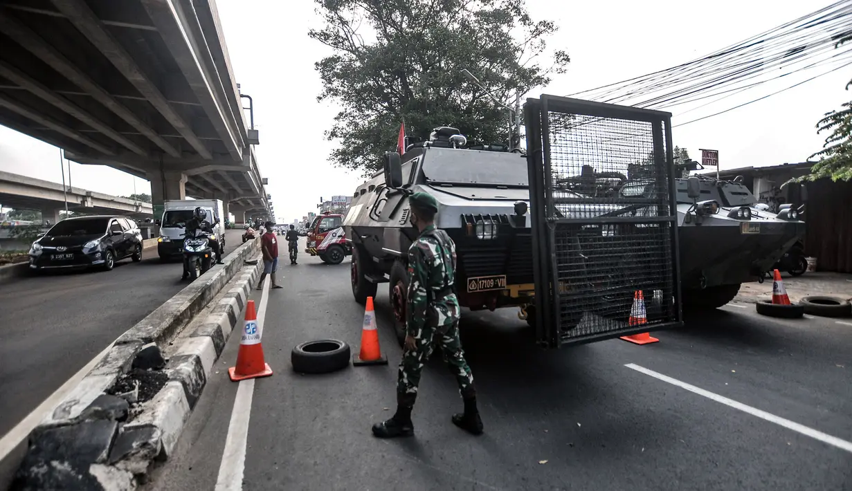Aparat TNI menjaga penyekatan PPKM Darurat di kawasan Lampiri, Kalimalang, Jakarta, Senin (5/7/2021). Petugas gabungan mengerahkan kendaraan taktis milik TNI dan Polri untuk menutup Jalan Raya Kalimalang. (merdeka.com/Iqbal S. Nugroho)