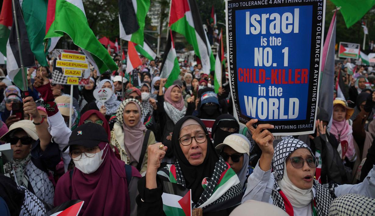 Ratusan orang memadati jalan di depan Kedutaan Besar Amerika Serikat di Jakarta untuk bersama-sama memperingati dua tahun perang di Gaza sekaligus menyuarakan kebebasan Palestina, Selasa 7 Oktober 2025. (AP Photo/Achmad Ibrahim)