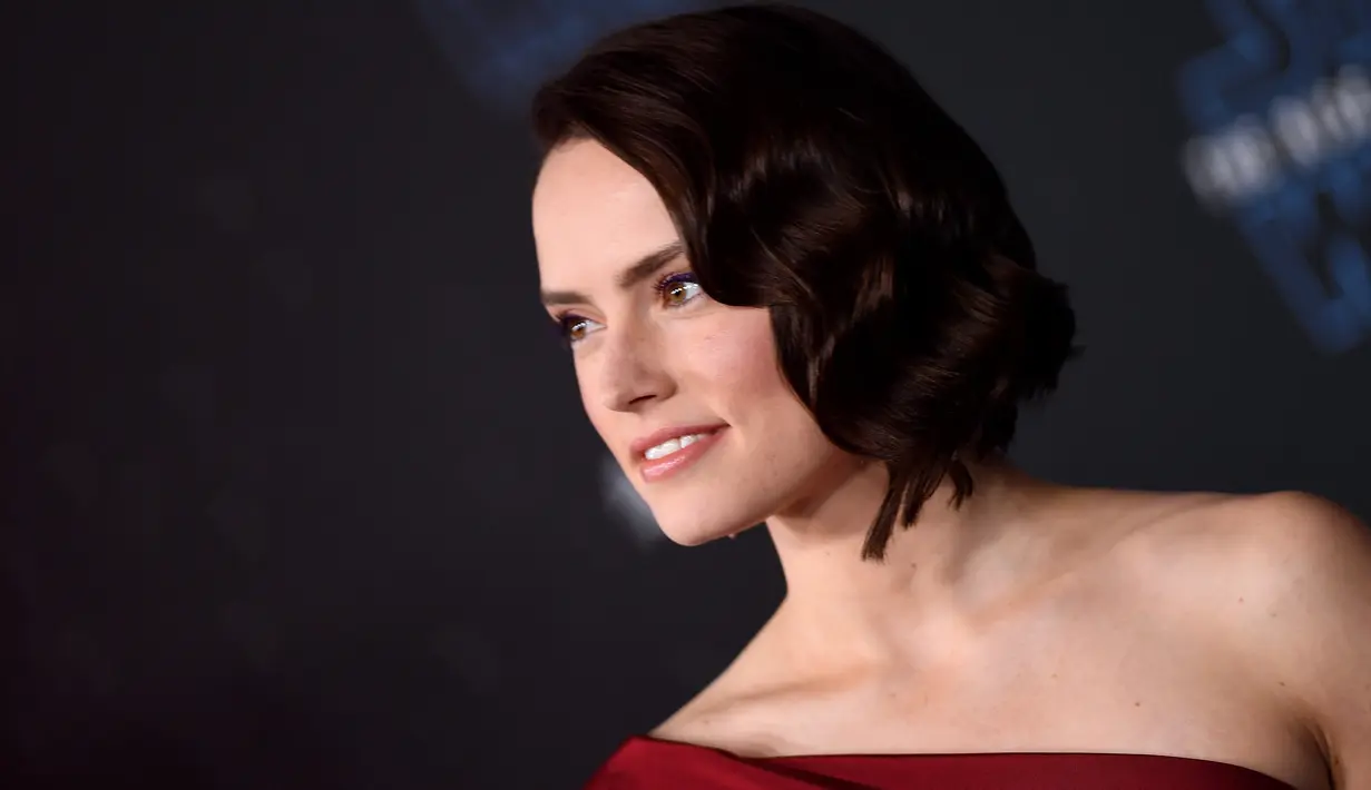 Aktris Daisy Ridley berpose saat menghadiri pemutaran perdana film Disney "Star Wars: The Rise Of Skywalker" di Hollywood, California (16/12/2019). Daisy Ridley tampil dengan rambut bergelombang pendek, memamerkan sepasang anting-anting ruby menggantung. (AFP/Valerie Macon)