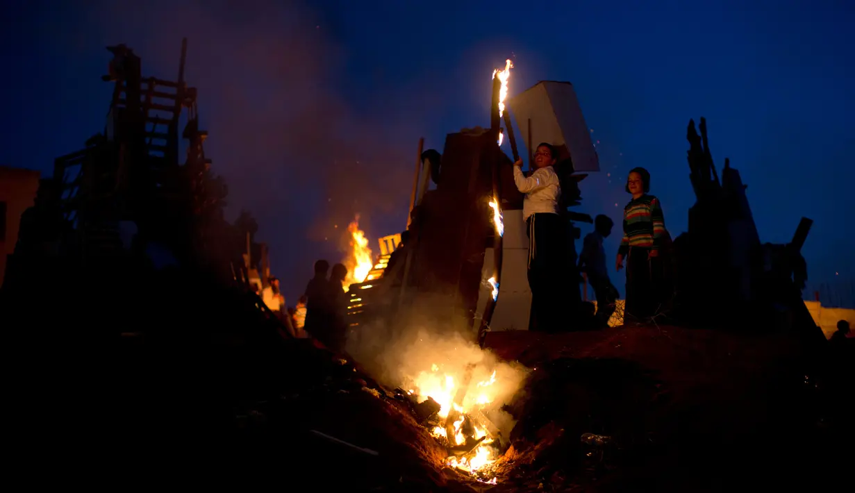 Anak-anak Yahudi Ultra Ortodoks berdiri di dekat api unggun saat perayaan hari Lag Ba'Omer di Bnei Brak, Israel (2/5). Lag Ba'Omer juga menjadi peringatan masa berduka ketika Rabbi Shimon Bar Yochai meninggal 1900 tahun lalu. (AP Photo / Oded Balilty)