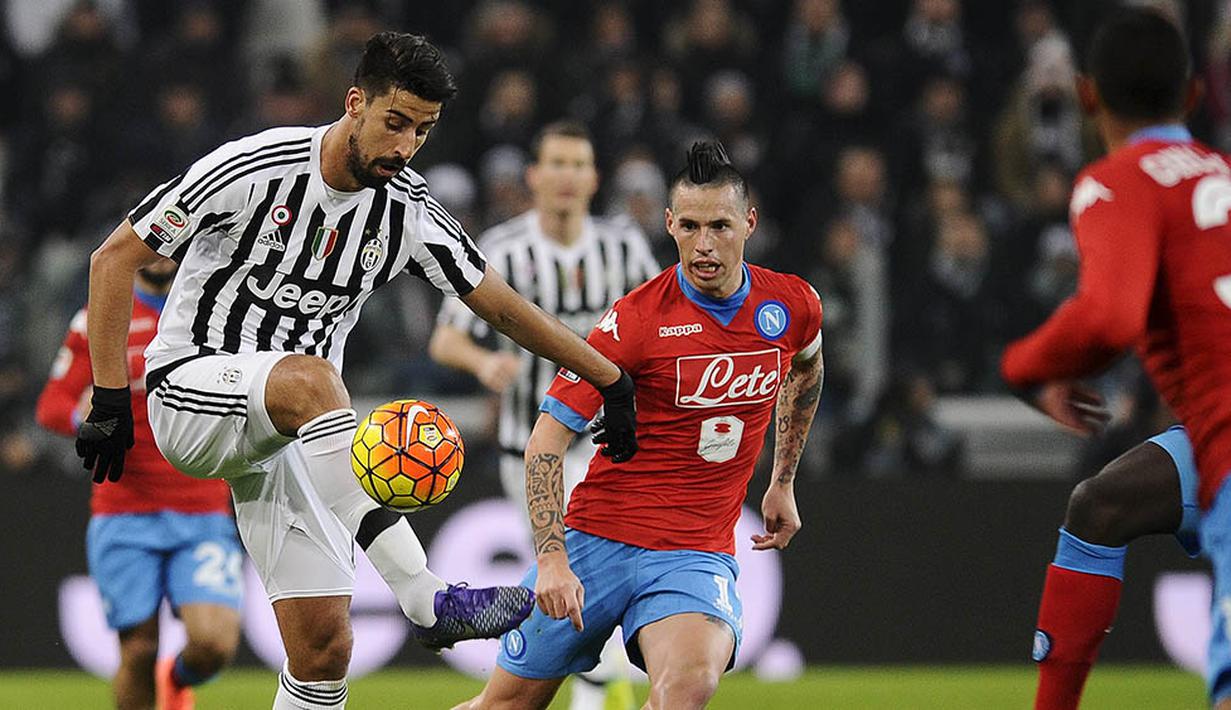 Pemain Juventus, Sami Khedira, mengontrol bola diawasi oleh pemain Napoli, Marek Hamsik. Kedua tim masih akan menjalankan 13 laga lagi dalam upaya perebutan scudetto. (Reuters/Giorgio Perottino)