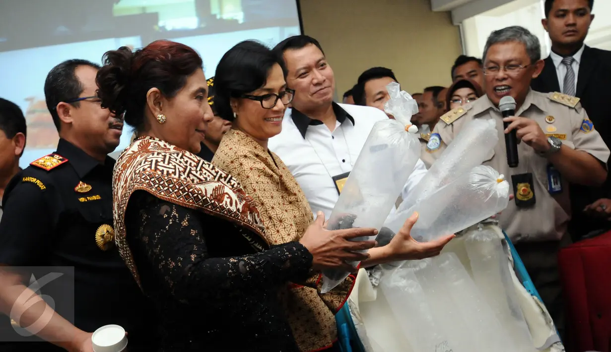 Menkeu Sri Mulyani Indrawati, Menteri KKP Susi Pudjiastuti, dan Direktur Tipidter Polri, Brigjen Pol Purwadi (kiri ke kanan) melihat barang bukti hasil penggagalan penyelundupan benih lobster di Jakarta, Rabu (26/10). (Liputan6.com/Helmi Fithriansyah)