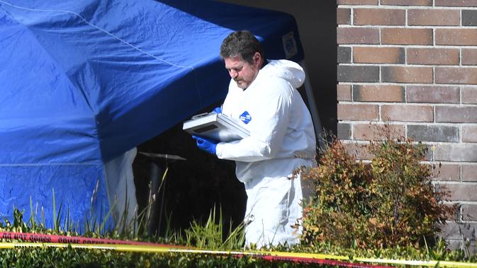 Seorang tim investigasi mengecek barang bukti di lokasi penembakan massal di Borderline Bar & Grill di Thousand di Thousand Oaks, California (8/11). Pelaku penembakan tewas dengan melakukan tembakan bunuh diri. (AFP Photo/Robyn Beck)