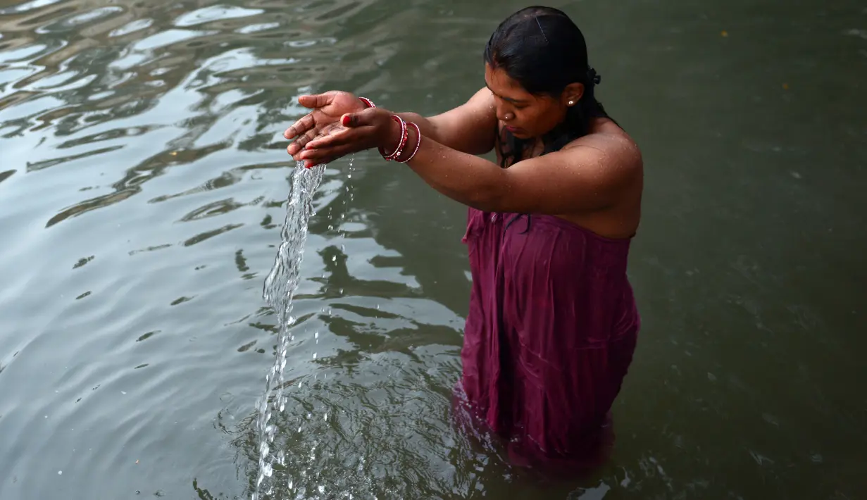 Wanita Hindu Nepal mandi suci disungai Salinadi saat Festival Swasthani Brata Katha di Katmandu, Nepal, (24/1). Selama festival ini, para wanita yang belum menikah berdoa untuk mendapatkan suami yang baik. (AFP PHOTO/Prakash mathema)