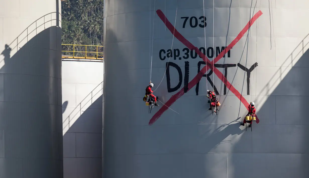 Aktivis Greenpeace melukis "DIRTY" ke sebuah silo di kilang Wilmar International di Bitung, Sulawesi Utara, Selasa (25/9). (Dhemas Reviyanto, Nugroho Adi Putera, Jurnasyanto Sukarno/Greenpeace Southeast Asia/AFP)