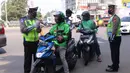 Polisi melakukan pemeriksaan pengendara motor saat pelaksanaan Pembatasan Sosial Berskala Besar (PSBB) di kawasan Gading Serpong, Tangerang Selatan, Sabtu (18/4/2020). PSBB di Tangerang Raya dalam menangani penyebaran virus corona (Covid-19) mulai berlaku sejak Hari ini. (Liputan6.com/Angga Yuniar)