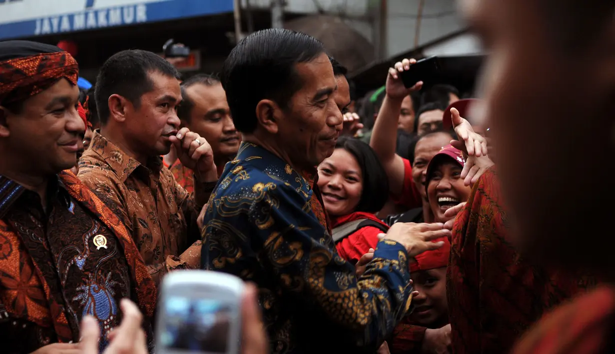 Presiden Joko Widodo (tengah) menyapa warga saat ikut dalam pawai kesenian Pesta Rakyat dan perayaan Cap Go Meh di Bogor, Jawa Barat, Kamis (5/3/2015). Perayaan Cap Go Meh di Kota Bogor berlangsung meriah. (Liputan6.com/Helmi Fithriansyah)
