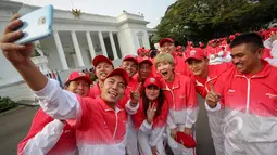 Sejumlah atlet berselfie saat berada di depan Istana Merdeka sebelum acara pelepasan kontingen sea games di Istana Merdeka, Jakarta, Selasa (26/5/2015). Indonesia menurunkan 522 atlet yang berlaga di 32 cabang olah raga. (Liputan6.com/Faizal Fanani)