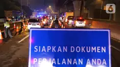 Petugas gabungan memeriksa dokumen pengendara yang melintas dari arah Jakarta di Pintu Tol keluar Cikarang Barat, kabupaten Bekasi, Jawa Barat, Kamis (6/5/2021) dini hari. Pemeriksaan tersebut terkait larangan mudik lebaran 2021 yang dimulai tanggal 6 hingga 17 Mei. (Liputan6.com/Herman Zakharia)