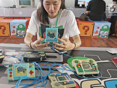 Pengunjung bermain game bot di acara bertajukThe 90s Festival, Jakarta, Sabtu (25/11). Dalam event tersebut terdapat berbagai jenis game, pernak-pernik, makanan, atribut, tokoh super hero, barang-barang generasi tahun 90an. (Liputan6.com/Herman Zakharia)