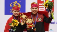 Pesilat Indonesia Riska Hermawan (kiri) dan Ririn Rinasih menunjukkan medali emas dalam nomor Seni Ganda Wanita Pencak Silat Sea Games 2021 Vietnam di Bac tu Liem Sport Center, Hanoi, Rabu (11/5/2022). (Bola.com/Ikhwan Yanuar)