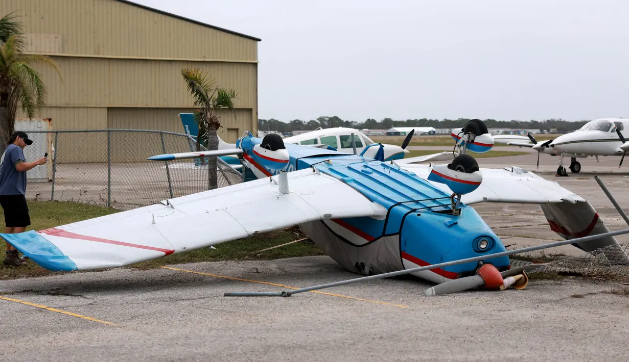Sebuah pesawat terbang terbalik di Bandara Kota Venice setelah Badai Milton melewati area tersebut pada 11 Oktober 2024, di Venice, Florida. (Joe Raedle/Getty Images North America/Getty Images via AFP)