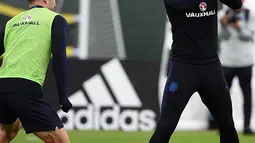Penyerang Inggris Harry Kane (tengah) memegang mainan ayam selama mengikuti sesi latihan di Repino (10/7). Inggris akan bertanding melawan Kroasia pada babak semifinal Piala Dunia 2018. (AFP Photo/Ellis)