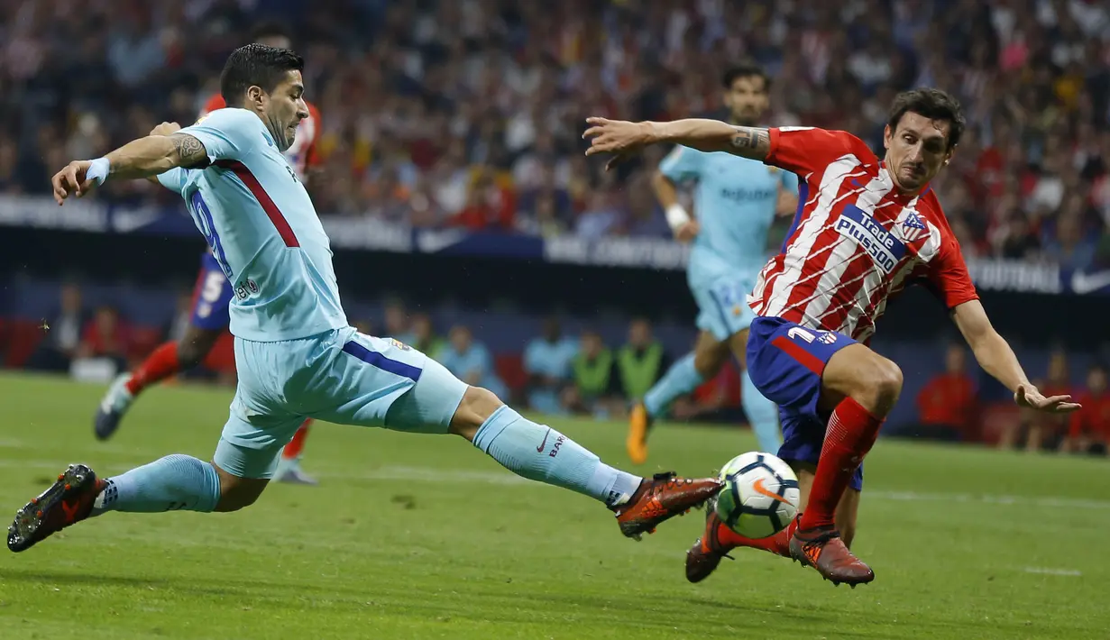 Bek Atletico Madrid, Stefan Savic, berusaha menghadang striker Barcelona, Luis Suarez, pada laga La Liga Spanyol di Stadion Wanda Metropolitano, Minggu (15/10/2017). Atletico Madrid bermain imbang 1-1 dengan Barcelona. (AP/Francisco Seco)