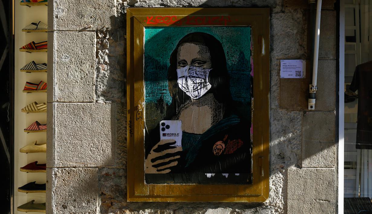 Poster seniman Italia TVBOY yang menggambarkan Mona Lisa karya Leonardo da Vinci mengenakan masker dan memegang smartphone di jalan Barcelona, Selasa (18/2/2020). Instalasi muncul setelah Mobile World Congress (MWC) 2020 batal digelar lantaran wabah virus corona yang mencekam. (PAU BARRENA/AFP)