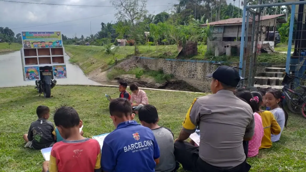 Brigadir Irvan membantu anak-anak mengakses bahan buku dengan pustaka kelilingnya (Liputan6.com/Rino Abonita)