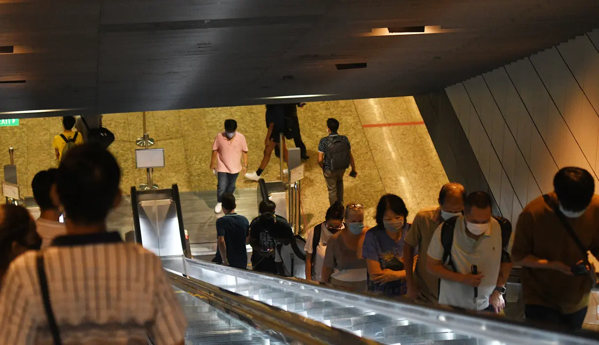 Orang-orang tampak mengenakan masker saat menaiki eskalator di sebuah stasiun kereta bawah tanah di Singapura pada 18 November 2020. (Xinhua/Then Chih Wey)