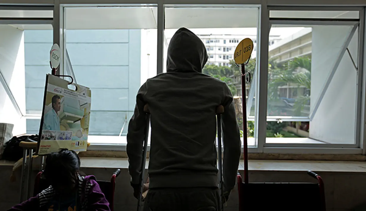 Alfin Tuasalamony membuang rasa jenuh menanti giliran waktu berkonsultasi dengan dokter. (Bola.com/Peksi Cahyo)