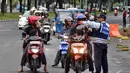 Petugas Dinas Perhubungan DKI Jakarta menunjukkan arah kepada para pemotor untuk tidak melewati Jalan Merdeka Barat, Jakarta, Kamis (1/1/2015). ( Liputan6.com/Miftahul Hayat)