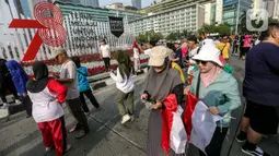 Tak hanya kostum berwarna Merah Putih, sejumlah warga juga tampak membawa bendera Indonesia. (Liputan6.com/Faizal Fanani)