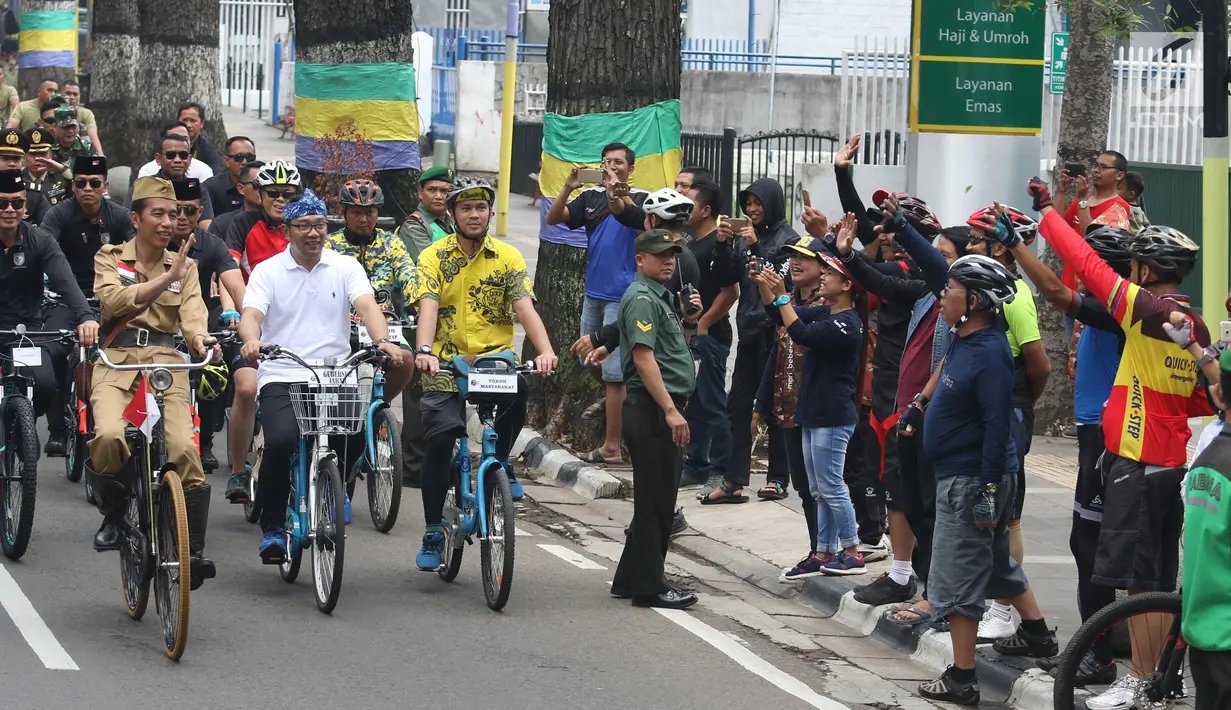 Presiden Joko Widodo atau Jokowi menyapa warga saat mengikuti Bandung Lautan Sepeda, Sabtu (10/11). Jokowi menaiki sepeda ontel dalam kegiatan tersebut. (Liputan6.com/Angga Yuniar)