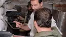 Presiden Suriah Bashar al-Assad Assad meninjau langsung tentara Suriah yang berada di garda terdepan bersama di Desa Marj al-Sultan, timur Ghouta, Damaskus, untuk melawan aksi terorisme, Suriah, Minggu (26/6).(REUTERS/Sana)