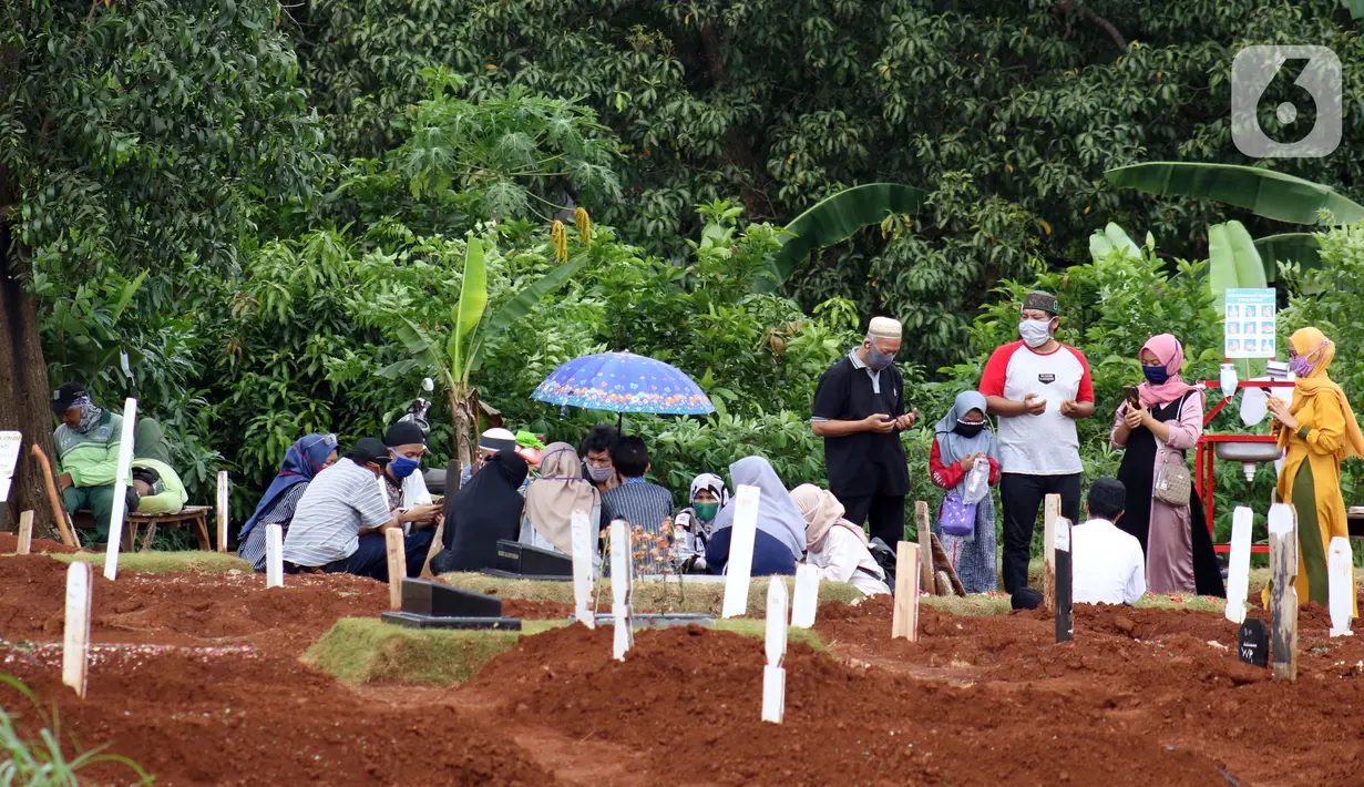 Peziarah berdoa di sisi makam jenazah yang diduga terinfeksi virus COVID-19 di TPU Pondok Ranggon, Jakarta, Minggu (24/5/2020). Momen Hari Raya Idul Fitri 1441 H dimanfaatkan sejumlah keluarga dan kerabat korban yang diduga terinfeksi COVID-19 untuk berziarah. (Liputan6.com/Helmi Fithriansyah)