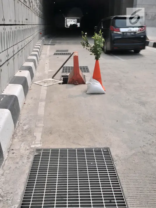 Cone block dan tanaman diletakkan dekat penutup lubang saluran air yang hilang di Underpass Mampang-Kuningan, Jakarta, Kamis (23/8). Tak ada petugas keamanan dari pihak Pemprov DKI atau Kepolisian yang berjaga di kawasan ini (Merdeka.com/Iqbal S. Nugroho)