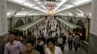 Para komuter berjalan melalui stasiun kereta bawah tanah atau metro Pyongyang di Korea Utara, 6 September 2018. Kereta bawah tanah Pyongyang Membentang sepanjang 22,5 km dengan 17 stasiun pemberhentian. (AFP / Ed JONES)
