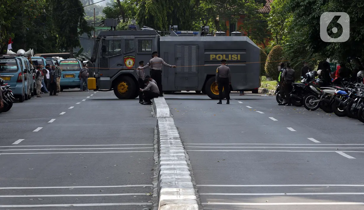 Petugas kepolisian menutup sementara akses jalan Kuningan Persada di sekitar Gedung Merah Putih KPK, Jakarta, Jumat (28/5/2021). Pengamanan gedung Merah Putih KPK dan sekitarnya diperketat menyusul informasi adanya aksi unjuk rasa. (Liputan6.com/Helmi Fithriansyah)